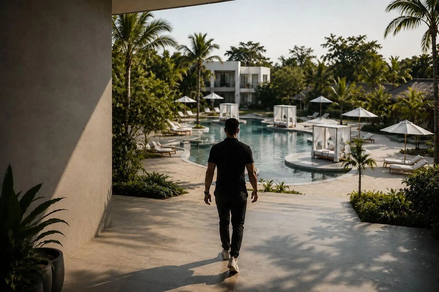 Pronoia regenerative destination — guest walking toward the lagoon pool