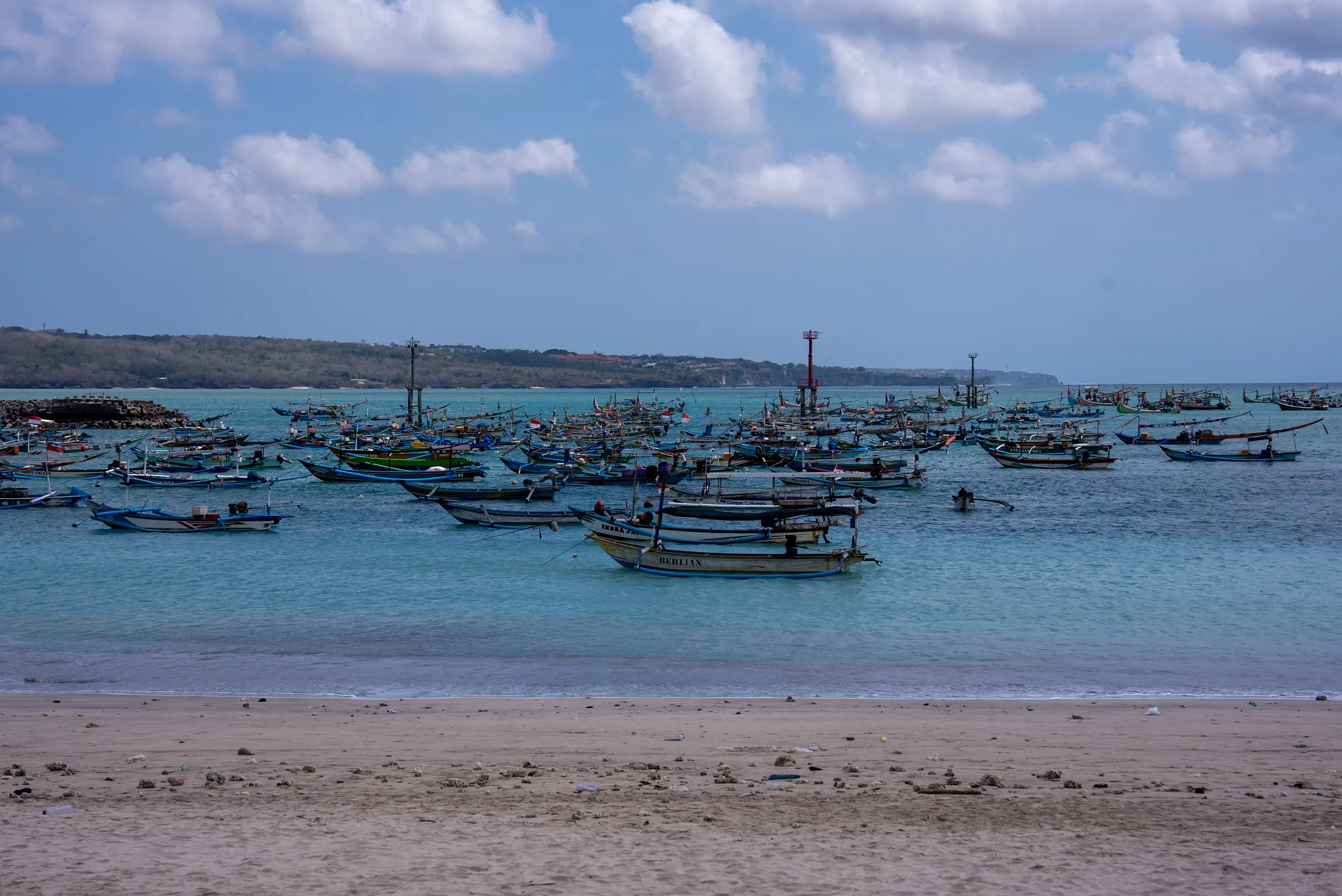 Traditional fishing boats on Jimbaran Bay in daylight